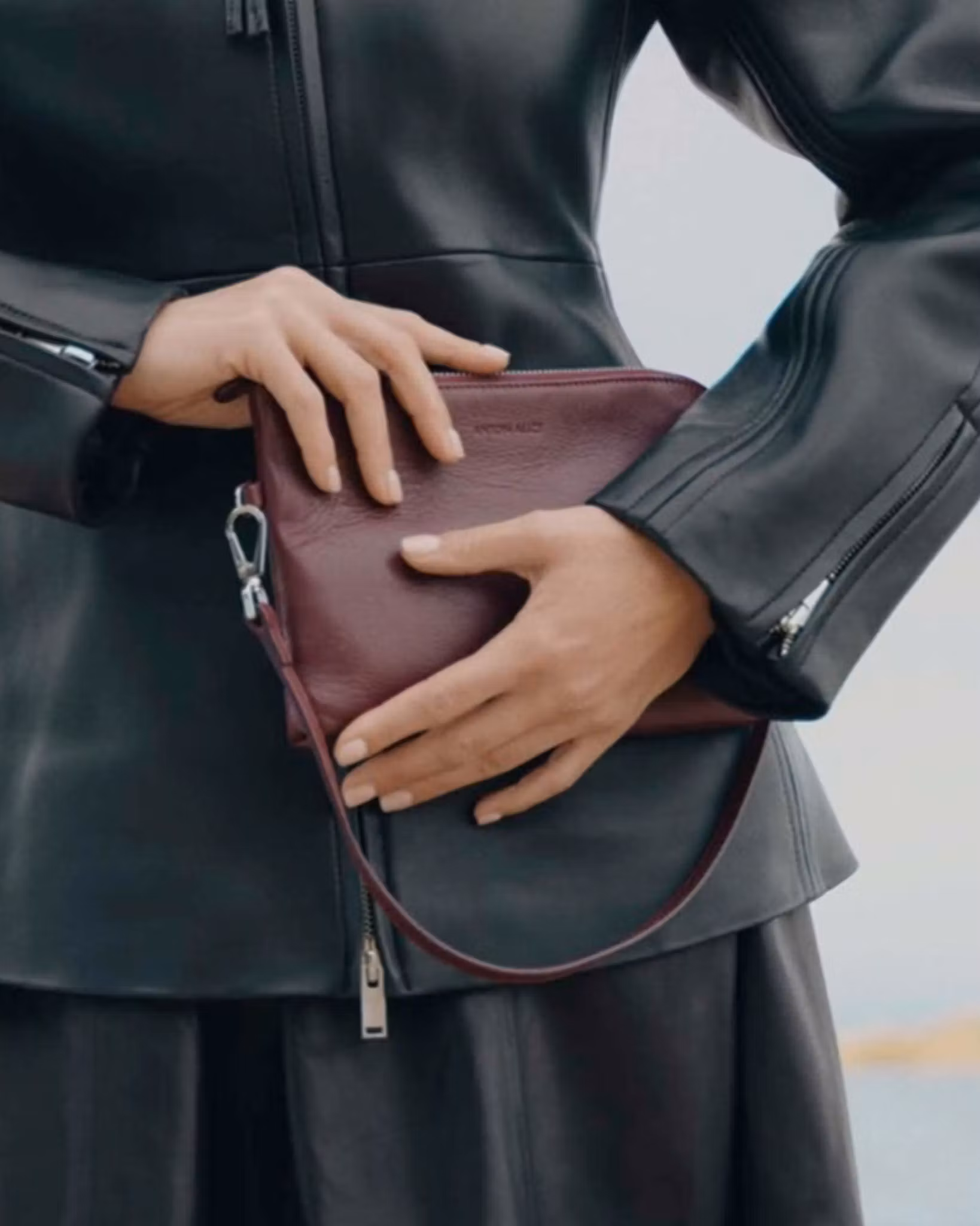 ANTON ALICE Pouch small leather bag in burgundy red, held in the hand