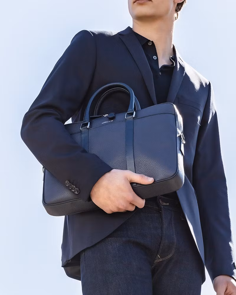 ANTON ALICE Briefcase leather laptop bag in navy blue, worn by a model