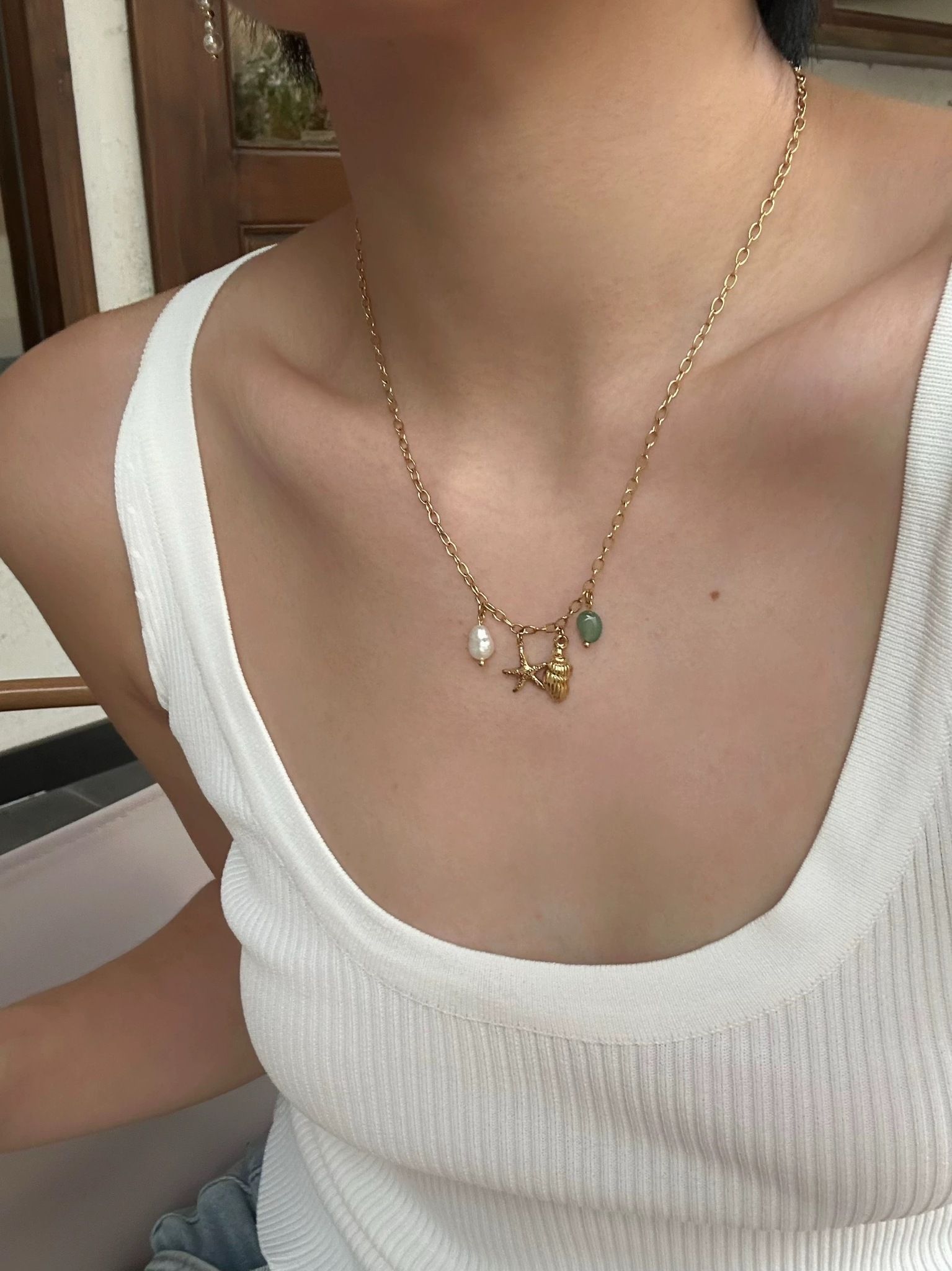 Halsband i stål med 18K guld med sjöstjärna och pärla