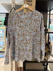 Ljusblå blus med brunt print stl 40