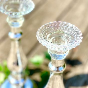 Två ljusstakar av silverfärgat glas