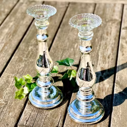 Två ljusstakar av silverfärgat glas