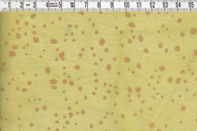 Ljusgrönmelerat bomullstyg med små beige prickar. Ca 110 cm