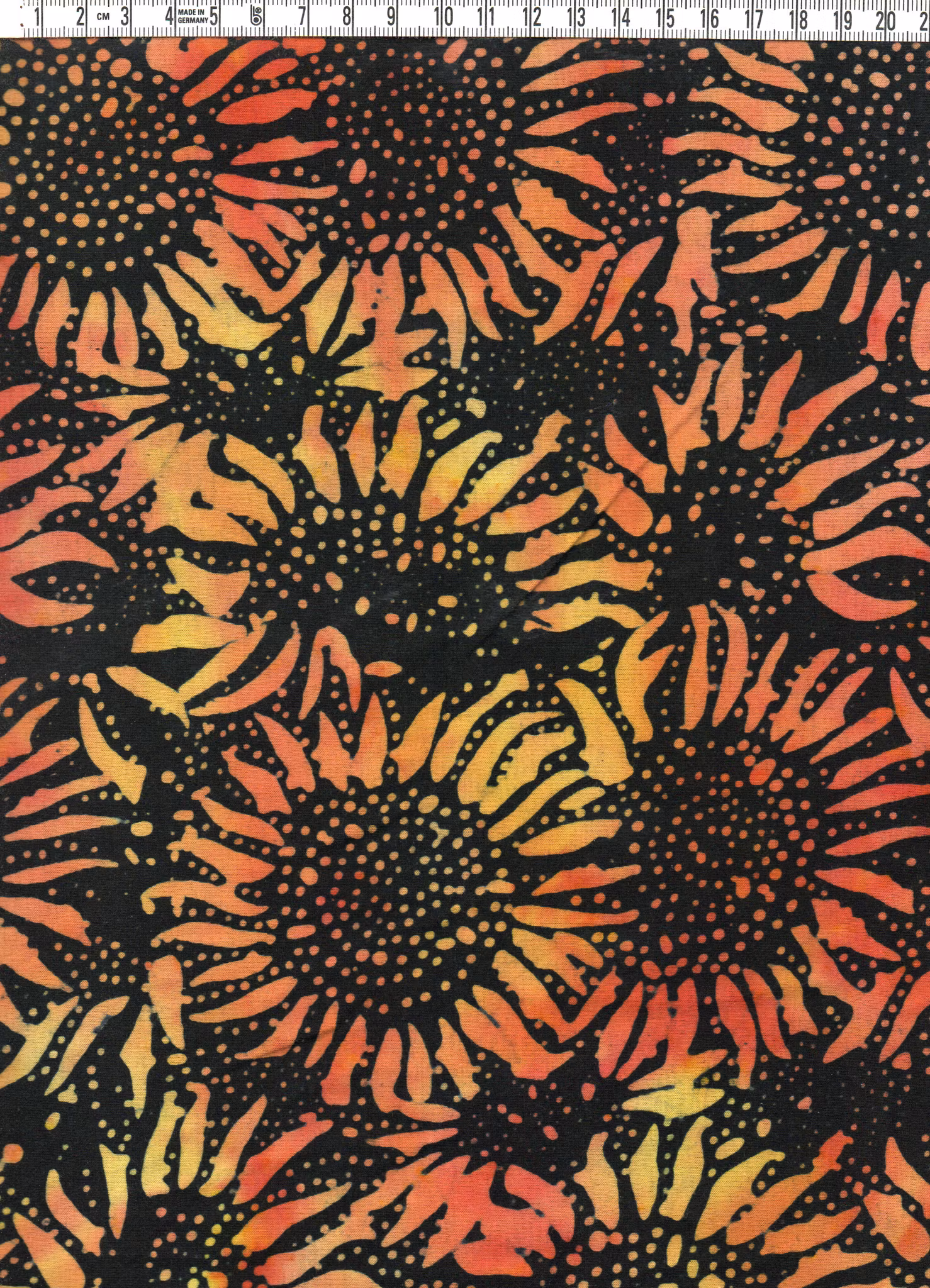 Gulorange solrosor på svart botten. Trikå 100% bomull. 140 cm brett