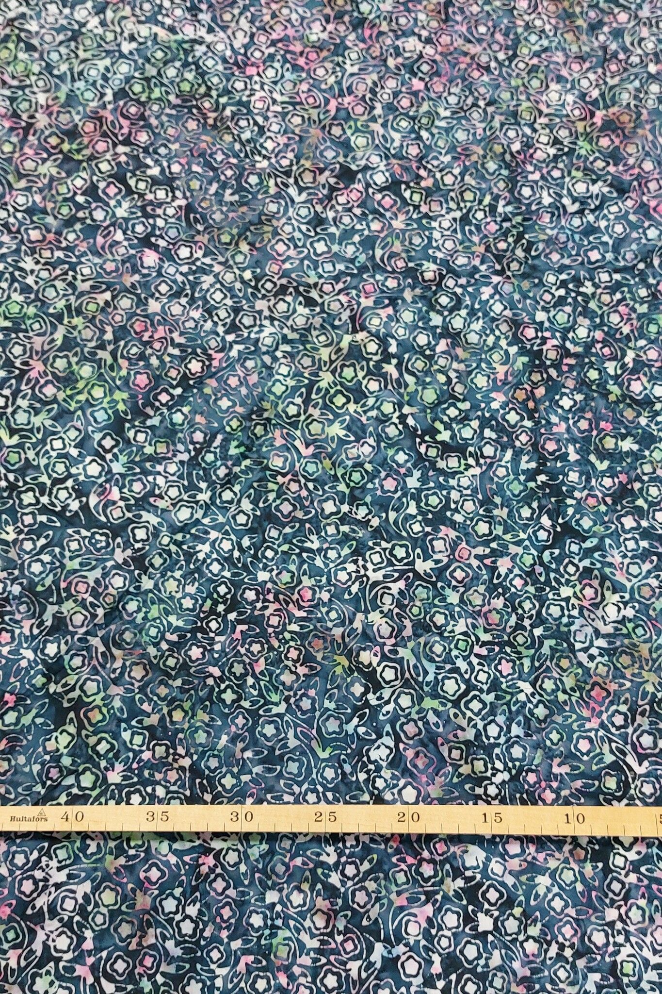 Mörktblått med gröna & violetta blommor.