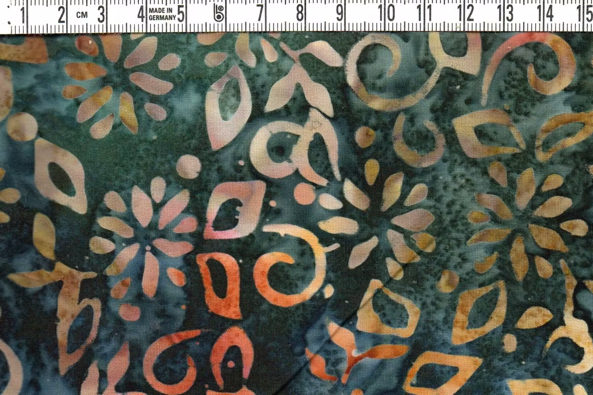 Mörkflammig med dovt färgade motiv. Batik bomull 110 cm