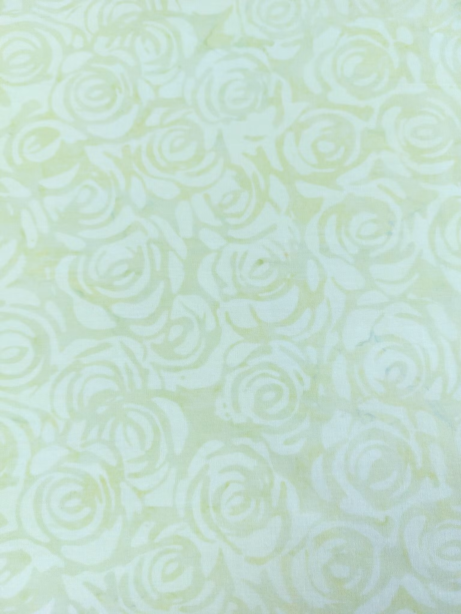 Blekt lite dovt ljusgrönt på ljus botten. Rosor. Batik bomull 110 cm