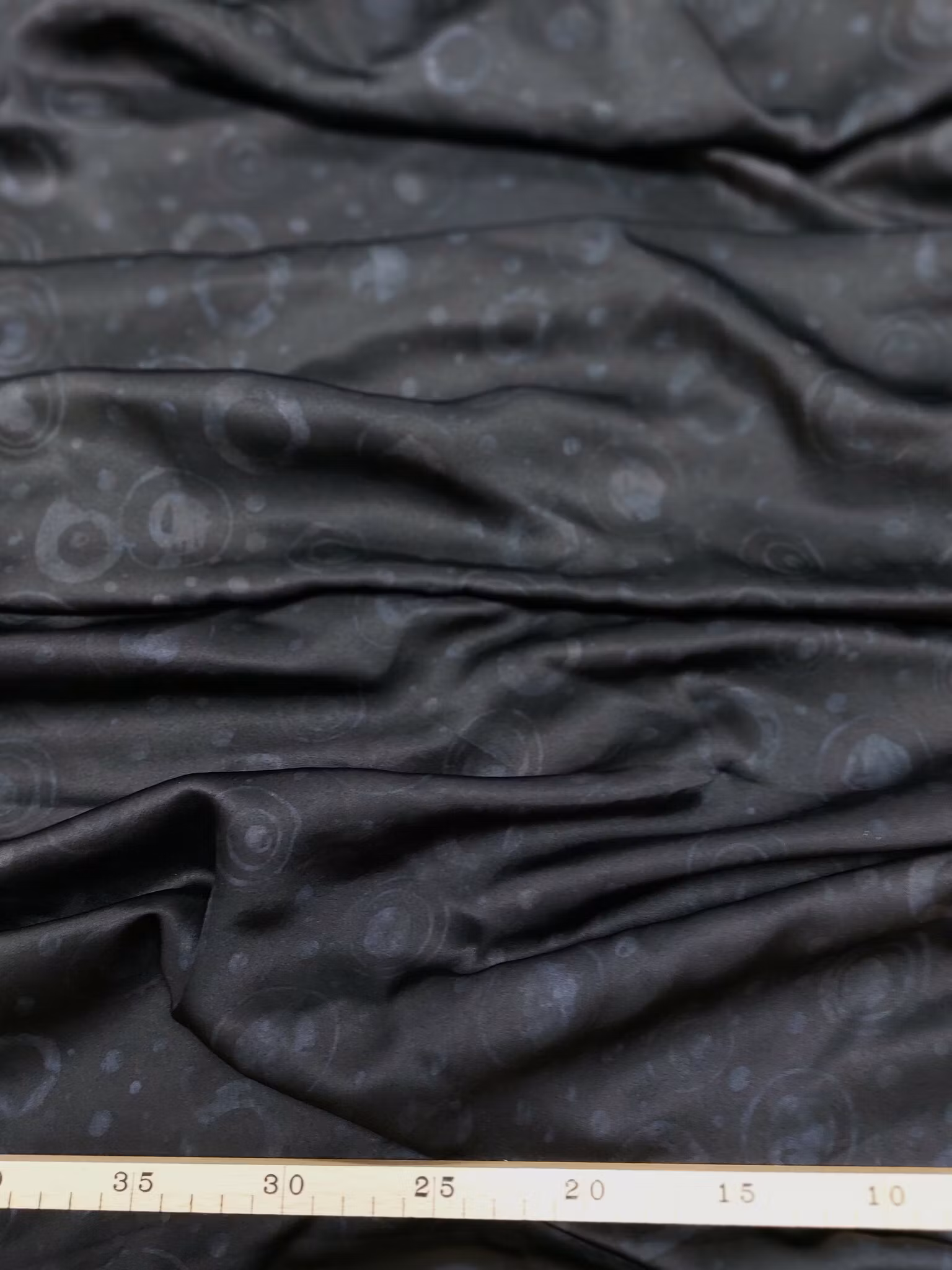 Högklassigt sidentyg i galant grått på svart.  Bredd 110 cm.
