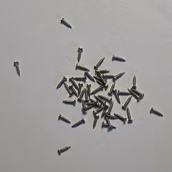 Spik/skruv, vitmetall, ca 5 mm lång