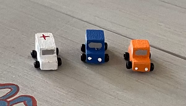 Tre bilar, vit, orange och blå