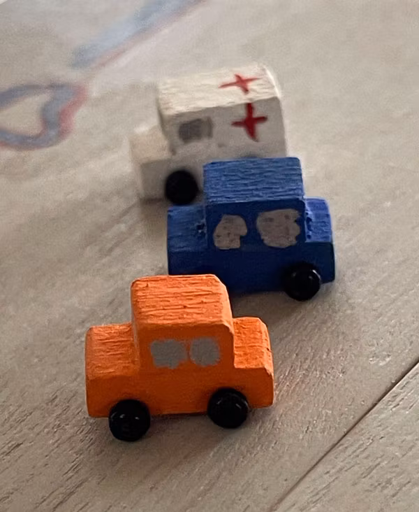 Tre bilar, vit, orange och blå
