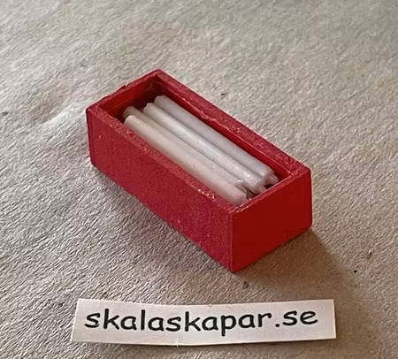 Vita ljus i röd trälåda