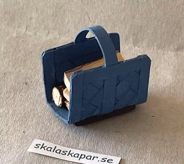 Vedkorg/vedhämtare med ved, mellanblå