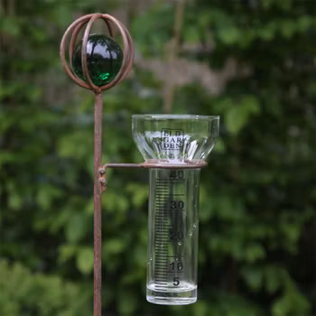 Regnmätare korn i rostig järn och glaskula i grönt - Eldgarden