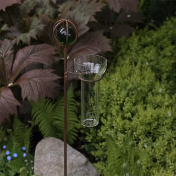 Regnmätare korn i rostig järn och glaskula i grönt - Eldgarden