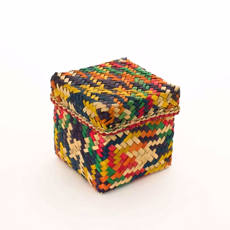 Kubisk korg med lock på, gjord av Patti-gras. Brokigt färgad i orange, gul, grön, röd, mörkblå. Bangladesh, Prokritee.