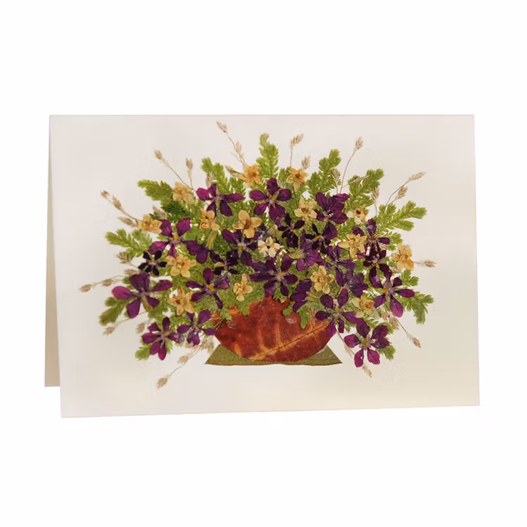 Litet vikt kort av återvunnet papper , fint dekorerat med torkade vilda blommor. Handgjort. El Salvador.
