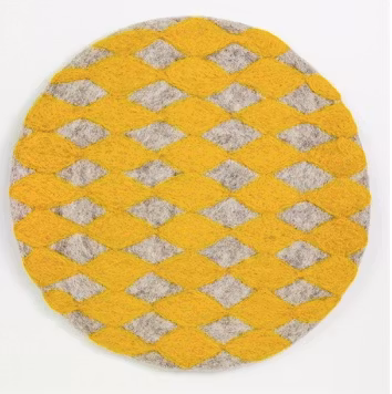Handtovad sittdyna Felt Harlequin från Afroart. Varmgul och grå färg. Diameter 38 cm.