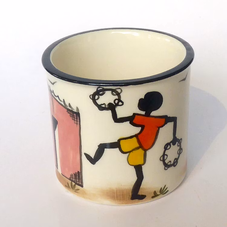 Mugg i keramik med glad vardagsscen från townshipsi Sydafrika. Lekande pojke. Kapula keramik Fair Trade.