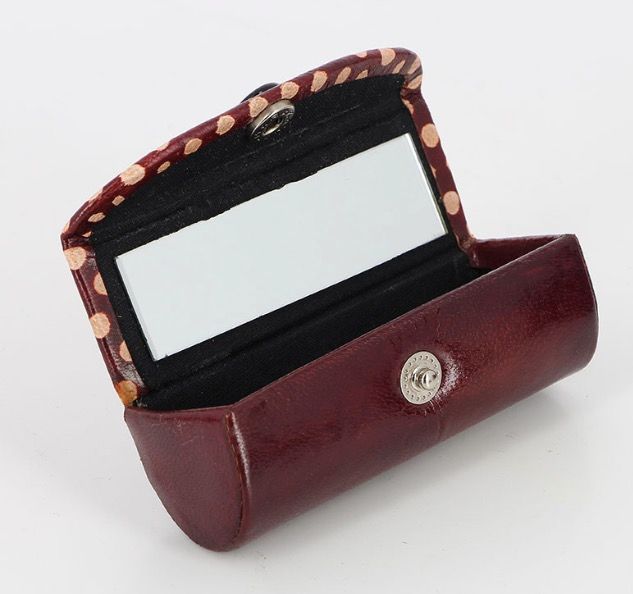 Rödbrunt etui eller fodral för läppstft, med spegel på insidan. Delvis dekorerad med prickar, Polka Dots. Getskinn. Fair Trade.