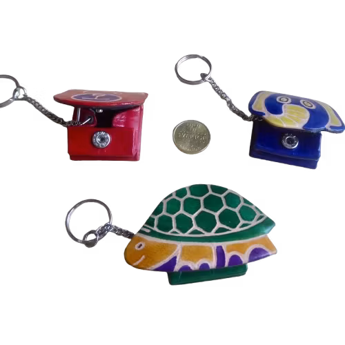Tre nyckelringar med öppet minifack i läder, olika motiv, björn, elefant, sköldpadda.  En 5-kronor-mynt som storleks-jämförelse. Fair Trade Indien.