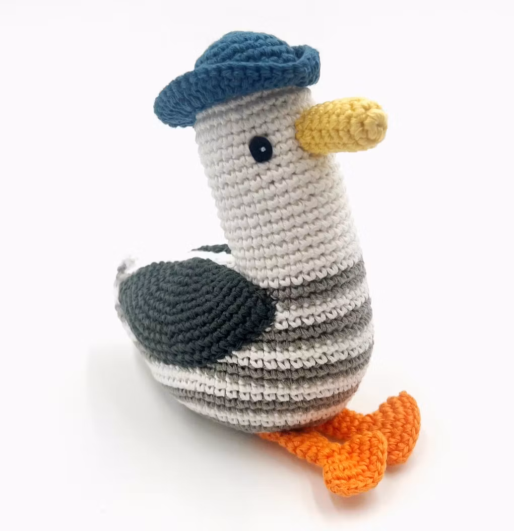 Rolig tygleksak med skallra, en handvirkad mås, ca 15 cm. Med en matchende hatt käckt på huvudet. Fair Trade Bangladesh.
