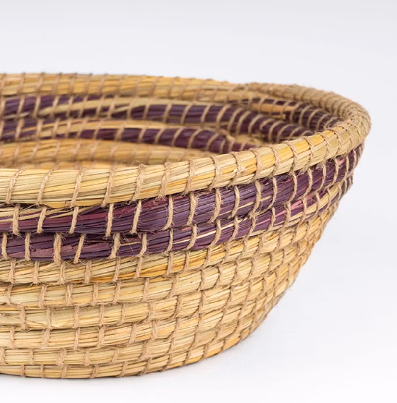 Rund, flätad korg av kaisagräs, naturfärg med mönster i auberginfärg. Fruktkorg. Bangladesh Fair Trade. Detajlbild.