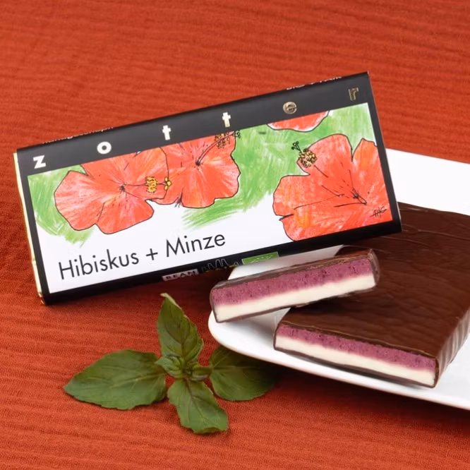 Zotter stor, mörk chokladpralin med utsökt smak, Hibiscus + Mint, ekologisk och Fair Trade. Bild med dekoration.
