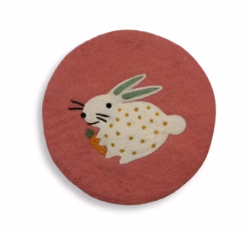 Underlägg Prickig vit påskhare eller kanin med morot, mot vintagerosa bakgrund. Tovat  Fair Trade Nepal.