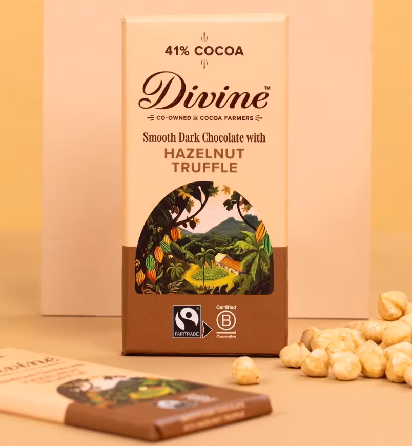 Divine choklad med hasselnötstryffel - Fairtrade, ekologisk, god Dekorationsbild med chokladkakor och skalade hasselnötter.