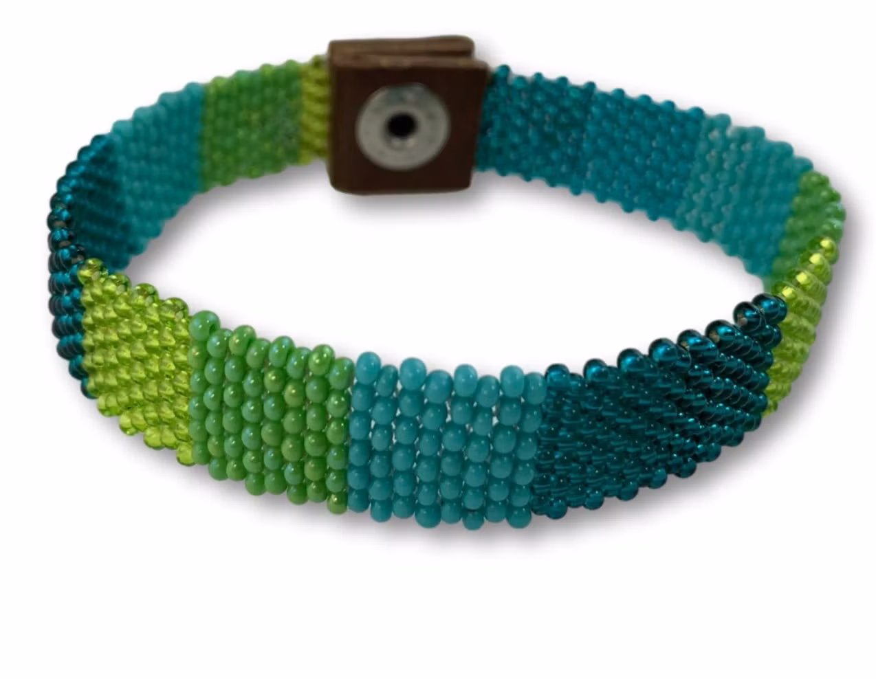 Armbnd av små glaspärlor i gröna nyanser. Noggrant trådarbete, traditionellt Zulu-arbete i modern design. Sydafrika.