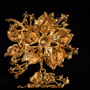Brosch, guldfärgad metall med strass. Art 09.