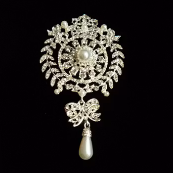 Brosch, silverfärgad metall med strass. Art 10.
