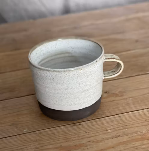 Vit mugg i mörkbrun lera