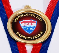 Medalj i storlek 32 mm med egen logo, band & text
