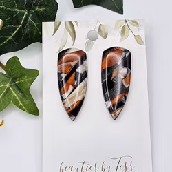 Glänsande daggers i svart, koppar och beige