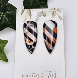 Glänsande daggers i svart, koppar och beige