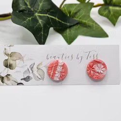 Skimrande studs i korall och vitt