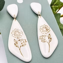 Glänsande vita örhängen med gulddetaljer