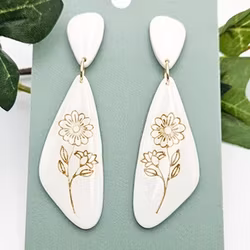 Glänsande vita örhängen med gulddetaljer