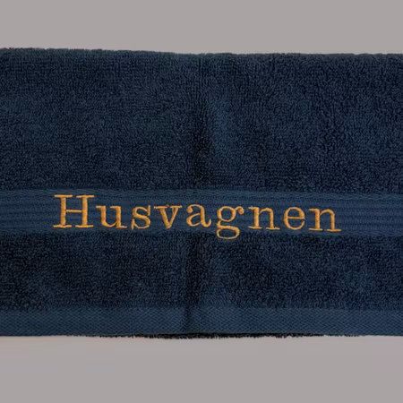 Gästhandduk med broderad text "Husvagnen"