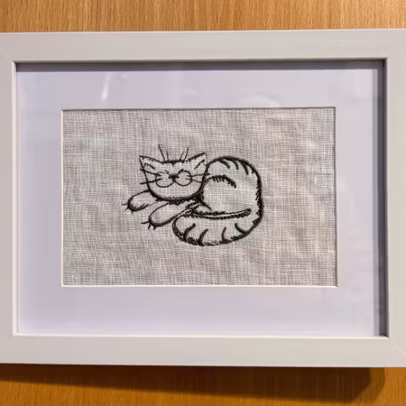 Broderad tavla med en gullig katt som sover. Välj färg på brodyren