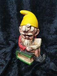 Spargris tomte som sitter på en bok retro