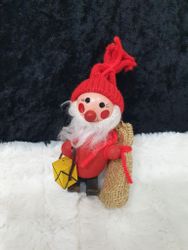 Liten trä tomte som har en säck och lykta