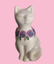 Rosa Ljung katt med lila blomsterkrans runt halsen