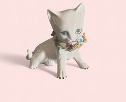 Porslins katt som sitter med blommor runt halsen*