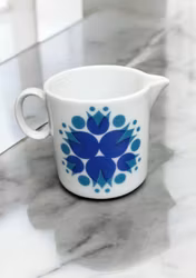 Söt mjölkkanna med blå blommor-retro