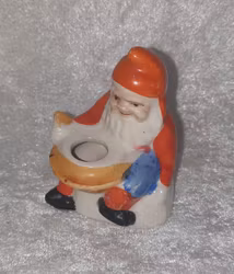 Äldre tomte som har en skål framför sig