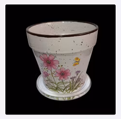 Söt kruka med rosa blommor och en fjäril