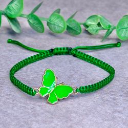 Somrigt armband med en grön fjäril